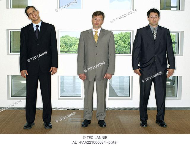 Three businessmen standing in a line