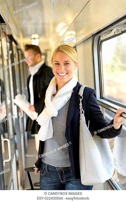 Woman smiling in train hall with luggage