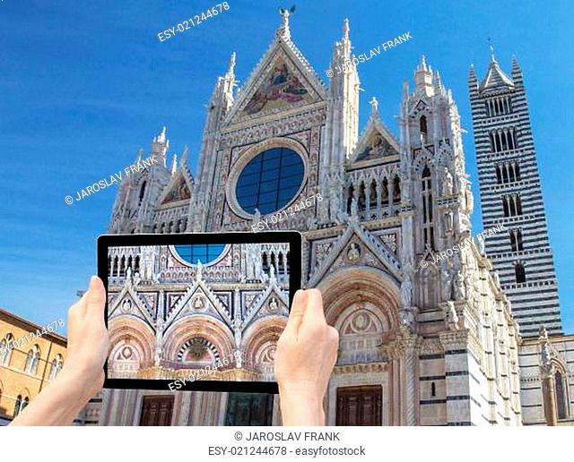In the bottom left of the photo are hands holding tablet, whose screen contains closeup photo of the cathedra.  Background of the photo contains photo of the...