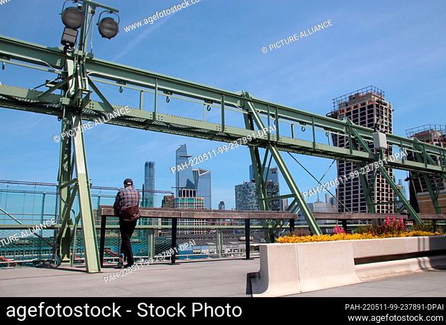 05 May 2022, US, New York: A visitor stands in a new park on the roof of a renovated landing bridge on the Hudson River. The approximately 8