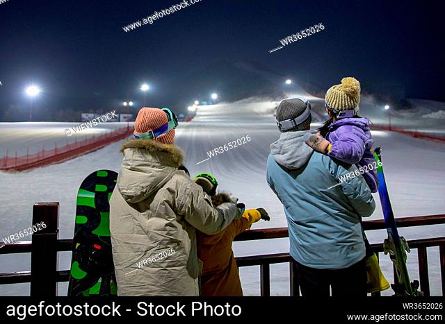 Ski resorts to see night view of the back of a family of four
