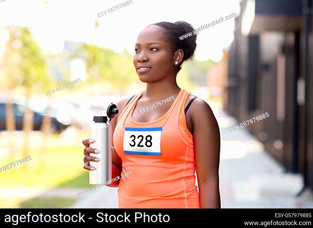 female marathon runner drinking water from bottle