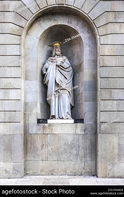 Statue with gilded crown in arched niche in Barcelona, Spain, Europe
