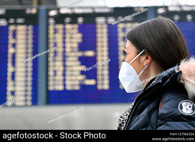 Themed picture trips in times of the corona pandemic. Young woman with face mask, mask at Munich Airport on December 6th, 2020