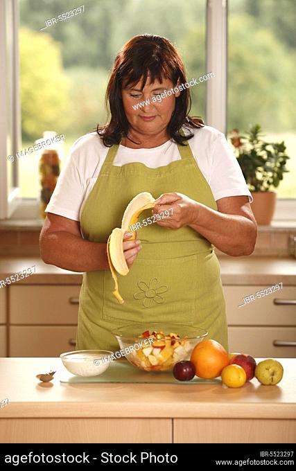 Woman prepares fruit salad, peel banana, prepare, bowl, peel, peel, yoghurt