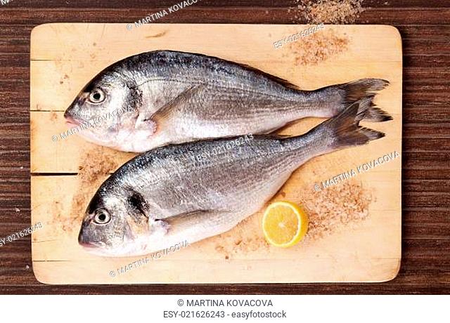 Two fish on wooding kitchen board