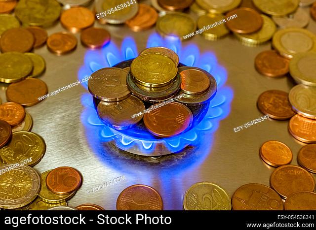 Coins of on the gas burner of the kitchen stove - business background