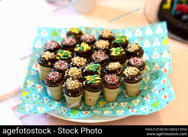 12 December 2020, Saxony-Anhalt, Magdeburg: On a plate are muffins in a waffle cup. They are decorated with colorful sprinkles