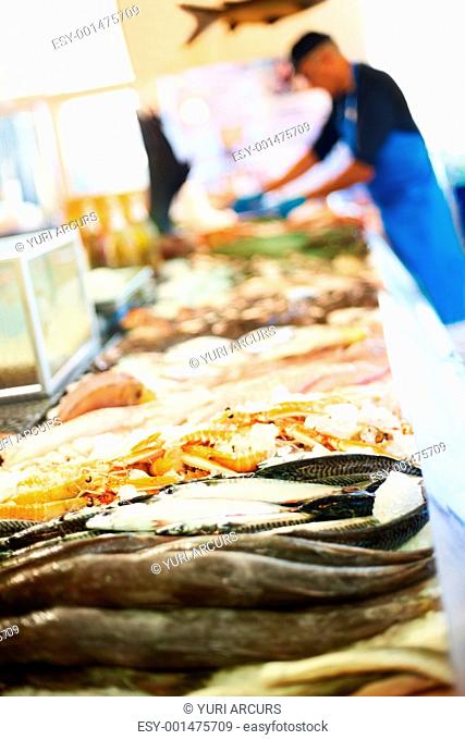Man working at fish shop with fish in focus