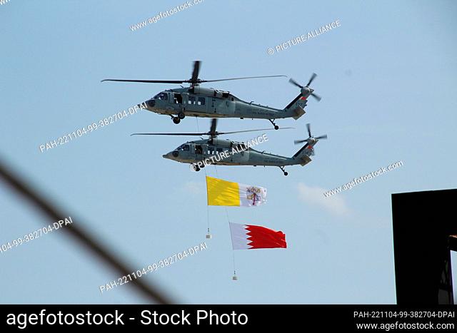 04 November 2022, Bahrain, Awali: Two helicopters fly with the flags of the Vatican as well as Bahrain at the end of an interfaith congress where the Pope gave...