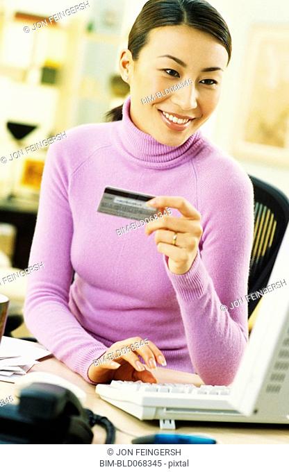 Asian woman shopping online with credit card