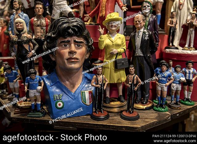 23 November 2021, Italy, Neapel: Small and larger figurines of football legend Maradona are on sale in a souvenir shop in the Spanish Quarter