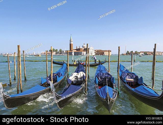 Venice, Venice Province, Veneto Region, Italy. Gondolas moored in the Bacino di San Marco. San Giorgio Maggiore behind. Venice and its lagoon are a UNESCO World...