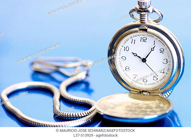 Silver pocket watch on a blue background