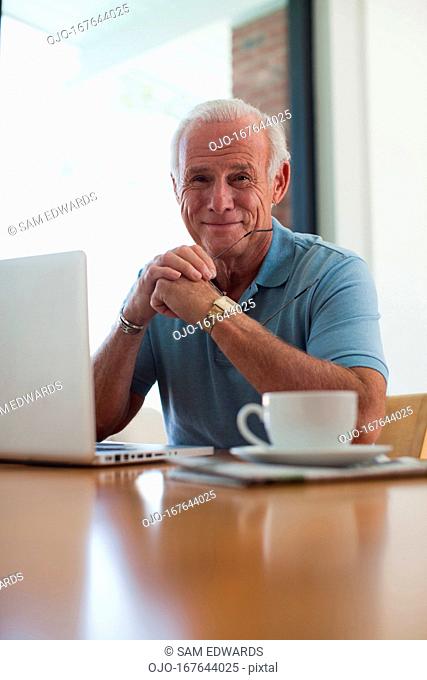 Older man using laptop indoors