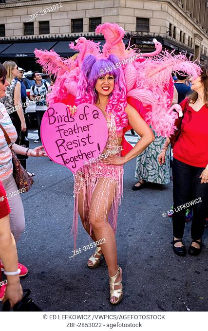 New York, NY - April 16, 2017. Activist Marni Halasa wears a costume decorated by pink flamingoes and carries a sign reading ""Birds of a feather resist...