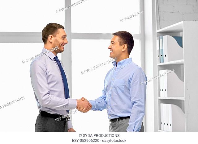 happy businessmen making handshake at office