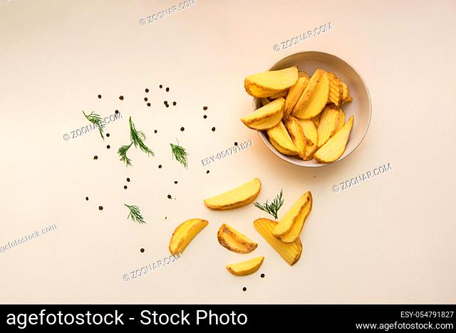 Crisp golden fried french fries potatoes in color background, top view