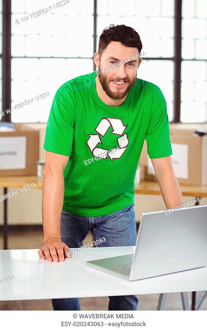 Portrait of man in recycling symbol tshirt working on laptop