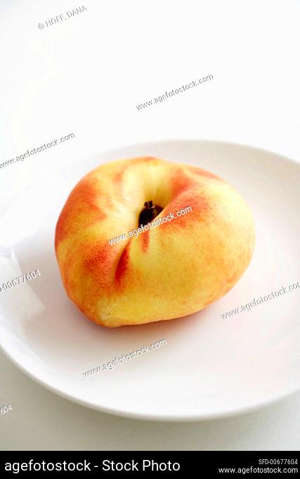 A Single Organic Saucer Peach on a White Plate