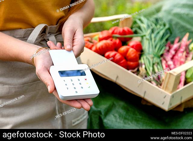 Female farmer swiping credit card at garden