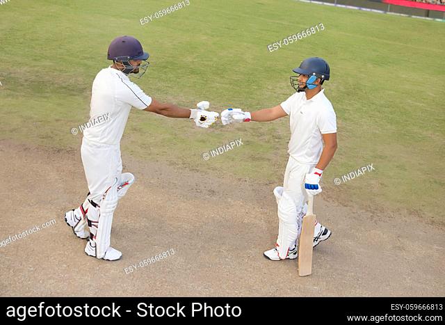 Batsmen congratulating each other during a match at the pitch