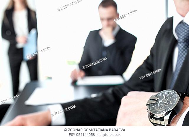 Time is money, business people in office, close up of man hand in wristwatch