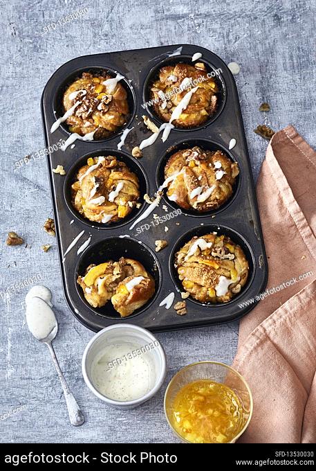 Kanelbullar buns with orange marmalade and walnuts baked in a muffin tray