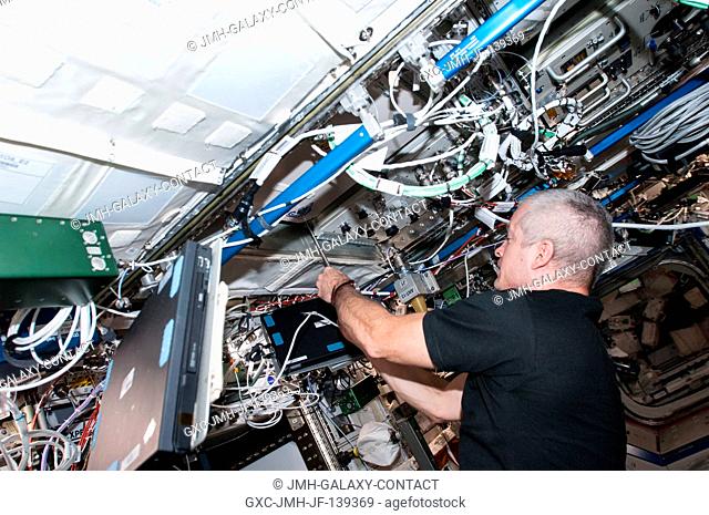 NASA astronaut Steve Swanson, Expedition 40 commander, works with the General Laboratory Active Cryogenic ISS Experiment Refrigerator (GLACIER) in the Destiny...