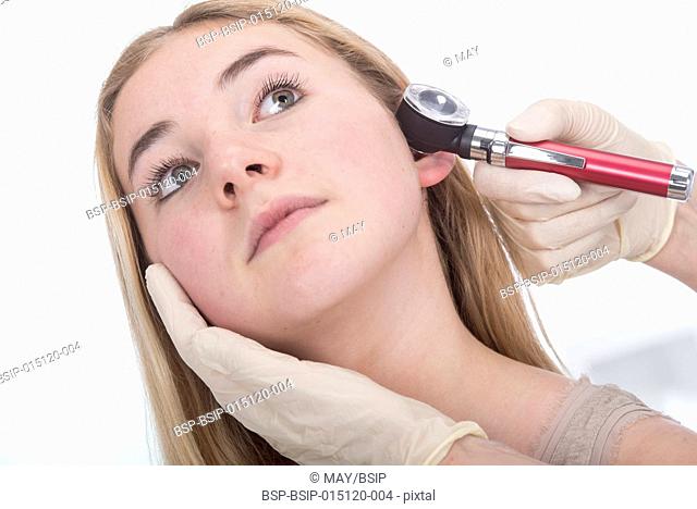 Doctor examining the ear of a teen