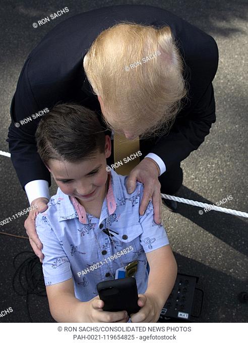 United States President Donald J. Trump poses for a selfie with a young person after making remarks at Take Our Daughters and Sons to Work Day on the South Lawn...