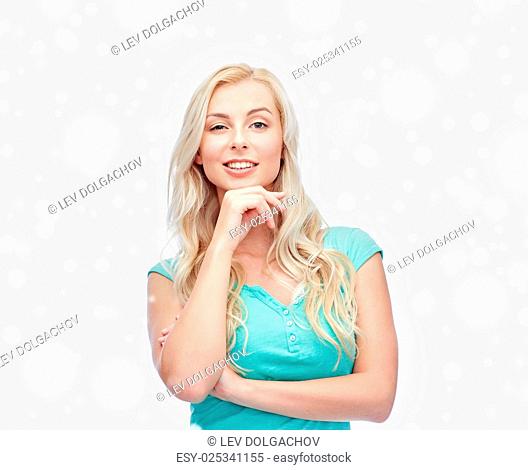 emotions, expressions, winter holidays, christmas and people concept - happy smiling young woman or teenage girl over snow