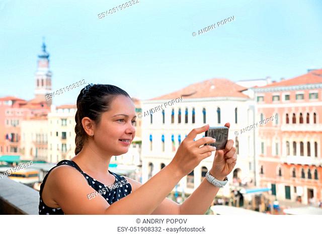 Cheerful Young Woman Clicking Photos On Cellphone In Venice