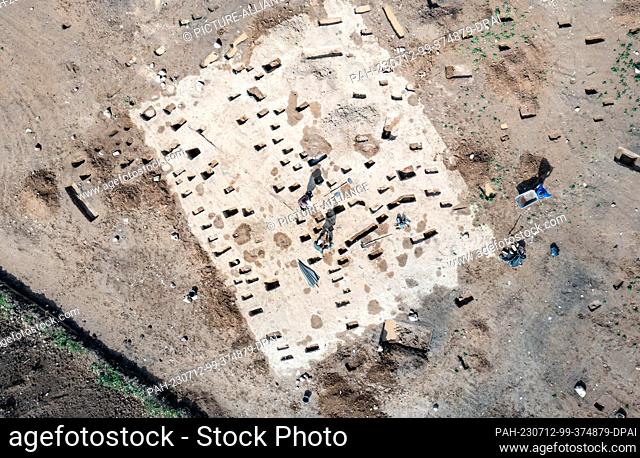 12 July 2023, Schleswig-Holstein, Flintbek: Excavation workers are working on settlement traces from the 4th to 5th century BC from the Migration Period in the...