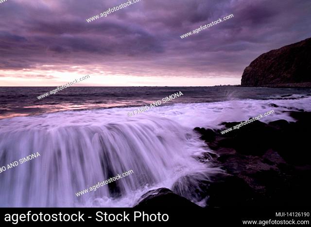 sunset landscape at the beach with sea ocean and waves in background - dramatic sky with sun and clouds - dusk light and horizon