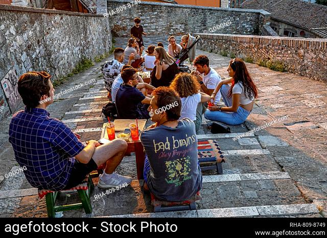 Young people sitting in a bar located on an urban staircase in Perugia, Umbria, Italy, Europe