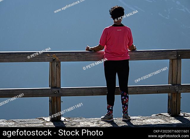 A woman relaxes at a mountain view near the Grossglockner in the Austrian Alps on July 7, 2023. (CTK Photo/Petr Malina)