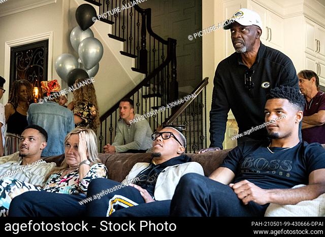 30 April 2021, US, Lake Forest: Amon-Ra St. Brown (2nd from right) sits on a couch between his mother Miriam Brown and brother Equanimeous St