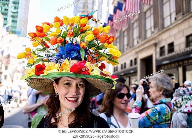 New York, NY - April 16, 2017. A woman wears a straw hat topped with dozens of tulips at New York's annual Easter Bonnet Parade and Festival on Fifth Avenue
