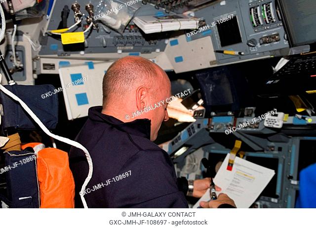 Astronaut Scott Kelly, STS-118 commander, looks over procedures checklists on the flight deck of Space Shuttle Endeavour during flight day seven activities...