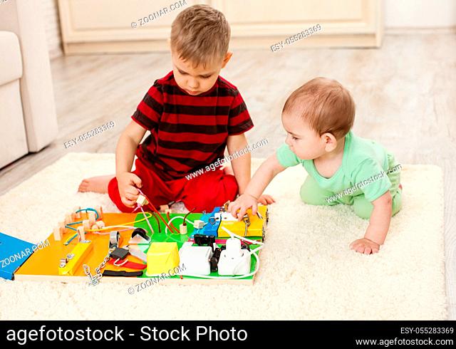 Handmade DIY sensory children's toy, two brothers play with busy board