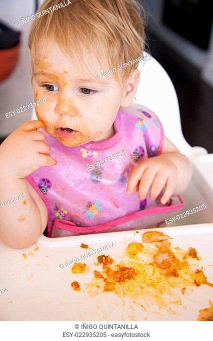 baby eating tomato meal with her hand