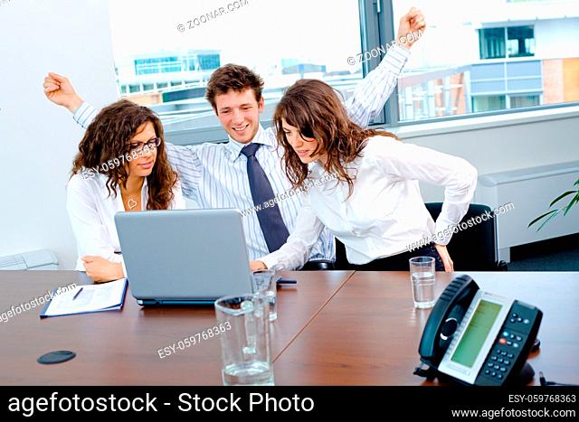 Happy successful business people sitting on meeting at office, working on laptop computer, smiling