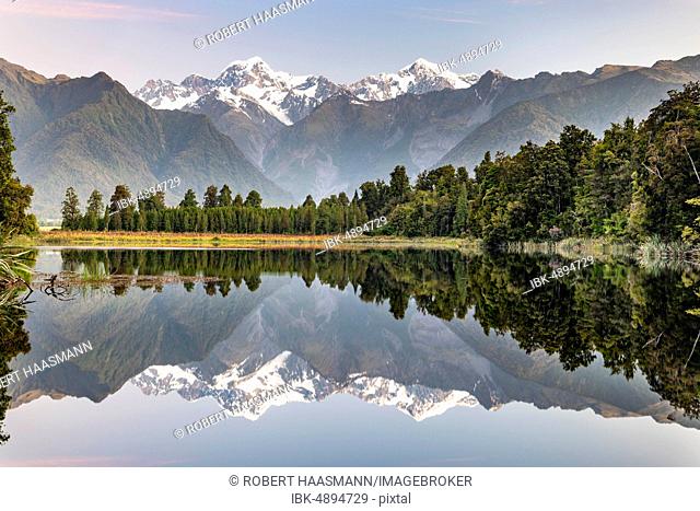 View of snow-covered Mount Cook and Mount Tasman, reflection in Lake Matheson, Westland National Park, New Zealand Alps, West Coast Region, South Island
