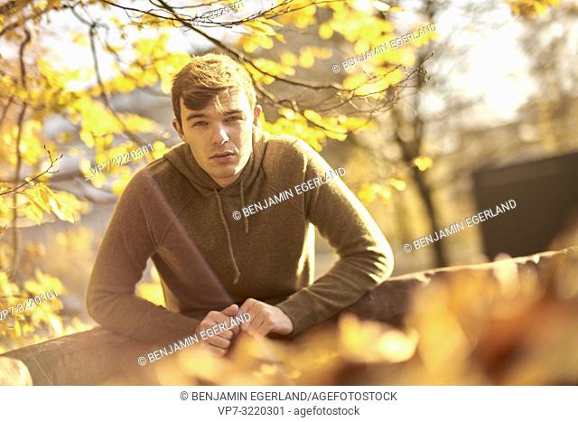 Young attentive man outdoors in autumn, in Munich, Germany