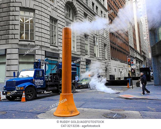 Steam vapor being vented through a typical Con Edison orange and white stack on the Financial District. New York City. USA