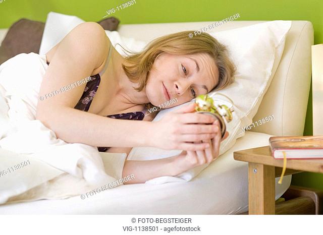 woman waking up with alarm clock - 02/03/2009