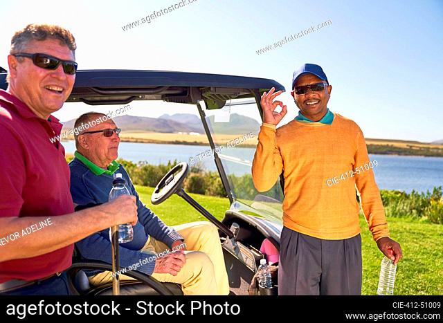 Portrait happy confident male golfer gesturing at sunny golf course