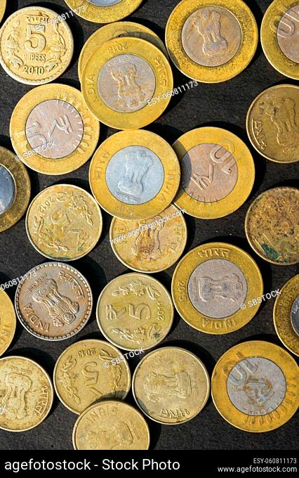 Mix of Gold Colored Indian Rupee Coin currency on rustic floor. Full Frame. Table Top View. Vertical. Business Finance and financial Investment Background