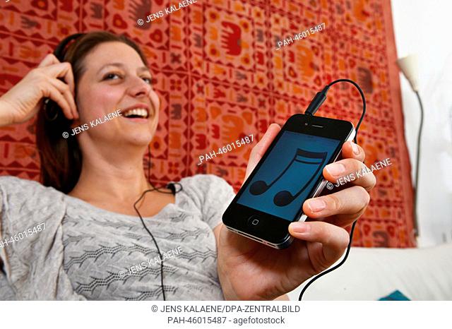 ILLUSTRATION - A young woman listens to music with her smartphone in Berlin, Germany, 25 January 2014. Photo: Jens Kalaene - MODEL RELEASED | usage worldwide